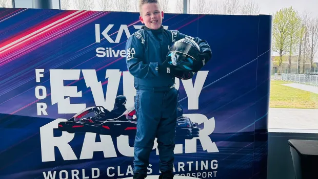 A young boy stands on the first place podium at CarFest.