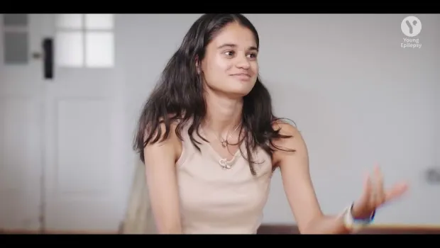 A young woman talks at a round table.