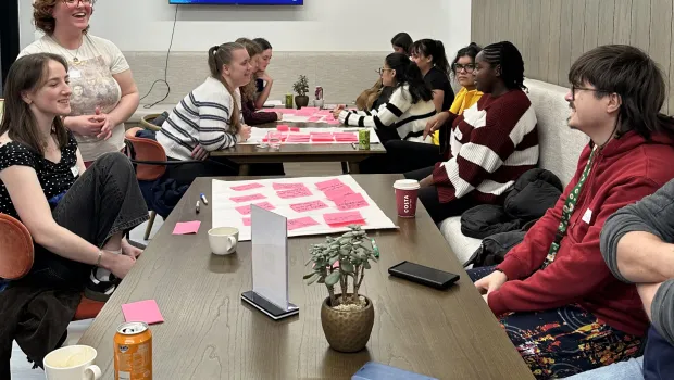 A group of young people discussing content ideas around a table.