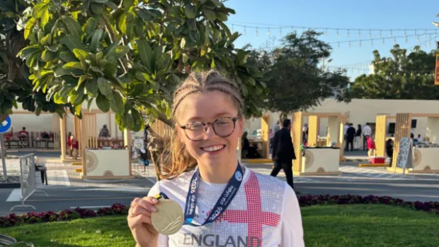 A young athlete holds up her medal.