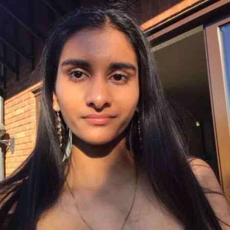 Photogragh of young woman looking directly at the camera, in the evening sunlight