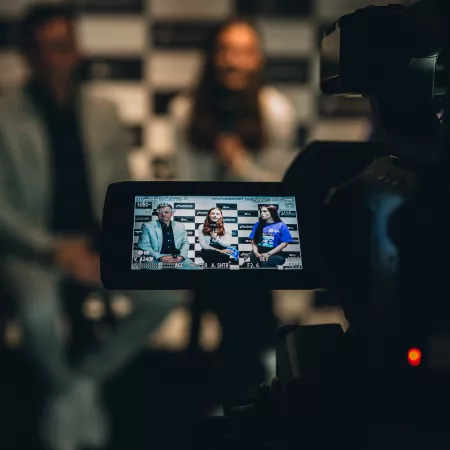 A camera is pointing at 3 people being interviewed