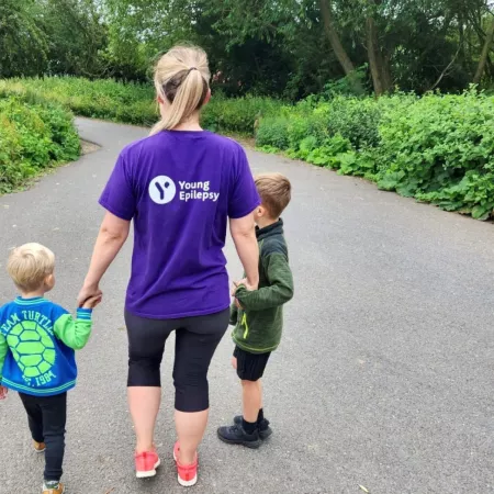 A mum wears a Young Epilepsy t-shirt while walking with her two sons.