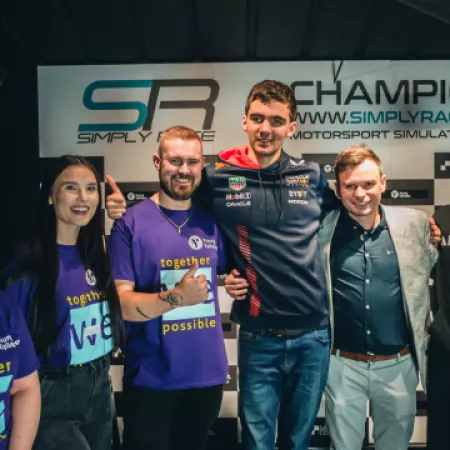 Members of the Youth Voice Network pose with car racing celebrities.