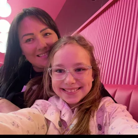 A mother and daughter smile in a selfie.