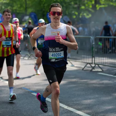 Jack give a thumbs up as he runs along a marathon route.