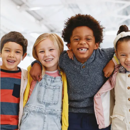 A group of young children smile while holding shoulders on the cover of a Young Epilepsy research report.
