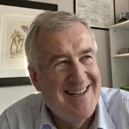 Simon Neville smiles from his office.