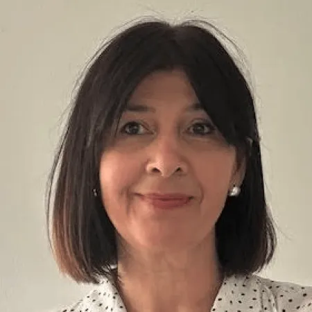 A woman with a brown bob smiles to camera.