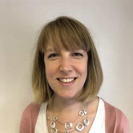 A young woman in a bob smiles against a white backdrop.