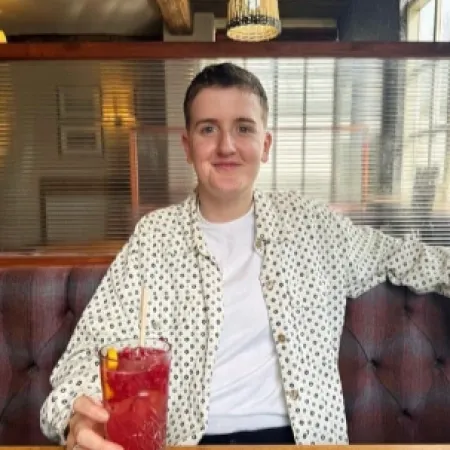 A young person enjoys a drink in a pub.
