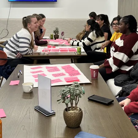 A group of young people discussing content ideas around a table.