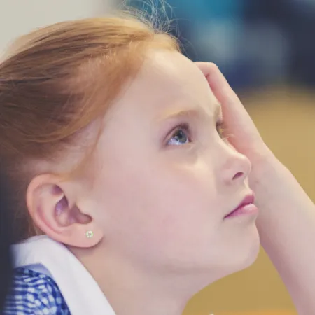 A school child looks up thoughtfully.