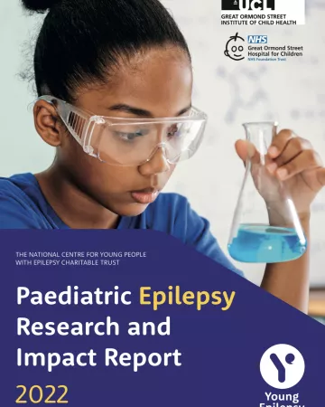 A child wearing goggles looks at a chemical in a beaker on the Research Report 2022 cover.