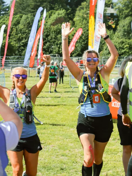 Women with arms raised running