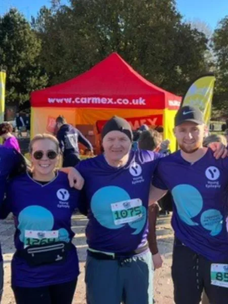 Team of runners smiling in young epilepsy tops