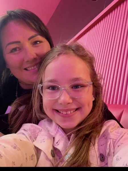 A mother and daughter smile in a selfie.