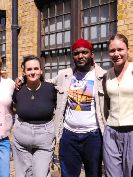 Young people stand arm in arm on a sunny day.