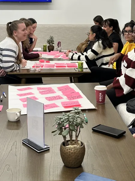 A group of young people discussing content ideas around a table.