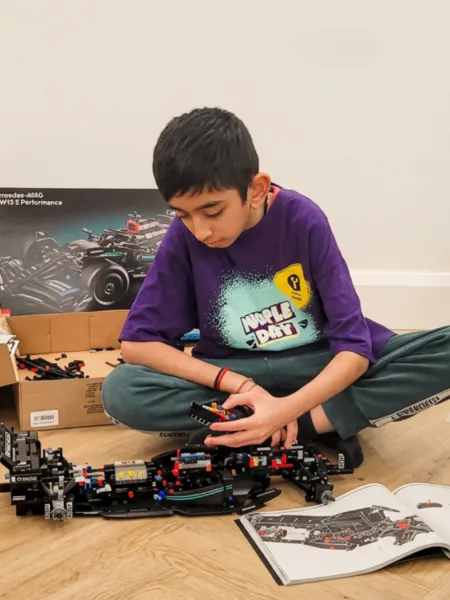A boy in a Young Epilepsy t-shirt plays with Lego.