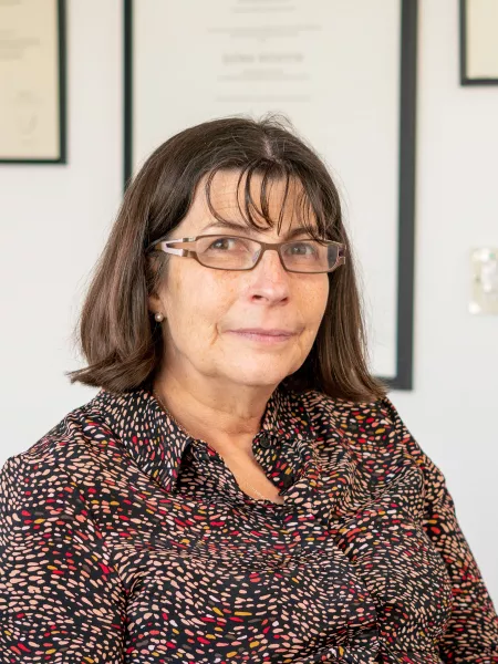Professor Helen Cross smiles slightly to camera in an office setting.
